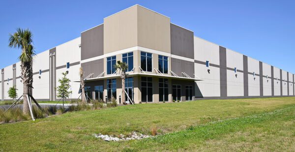 A large warehouse facility with a drainage easement in the lawn nearby.